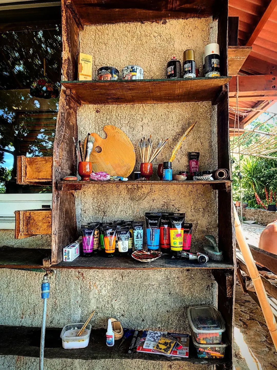 Estantería con pinturas y pinceles